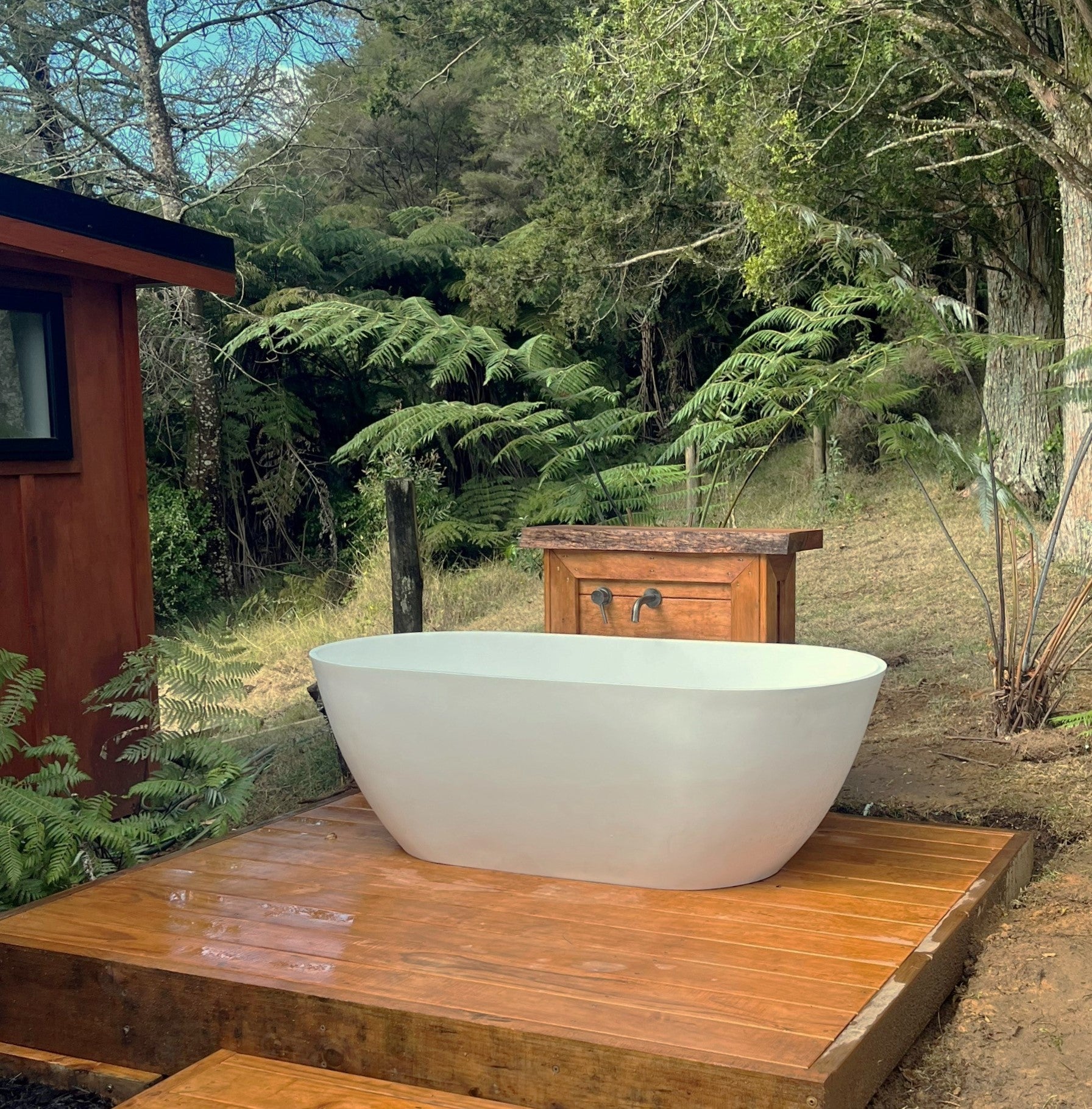 Justina Bath with outdoor plinth and wall mounted spout and mixer. Stonebaths.